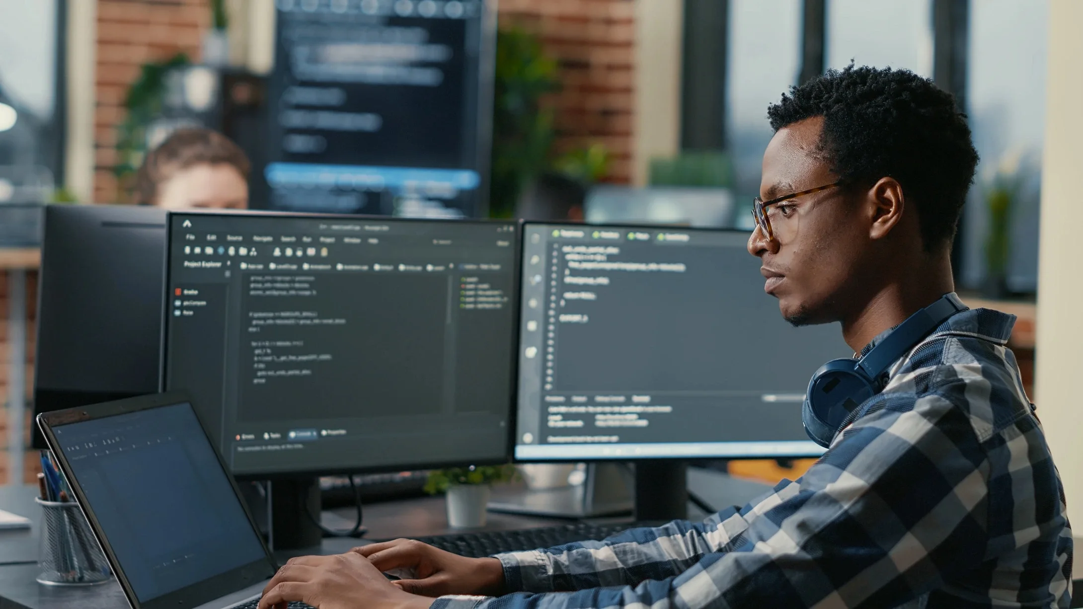 Mastering Markdown - Write and Format with Ease | sofware developer thinking while touching beard while typing laptop sitting desk with multiple screens parsing code focused database admin working with team coding background